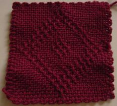 a red knitted square sitting on top of a table