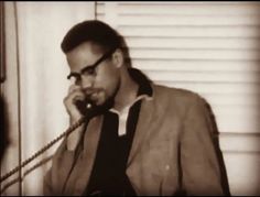 a man with glasses talking on a phone