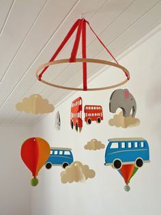 a mobile with cars, buses and hot air balloons hanging from the ceiling