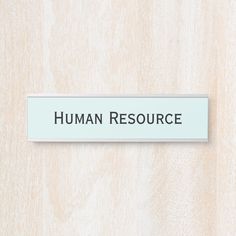 a white sign that says human resources on the side of a wooden wall with black lettering