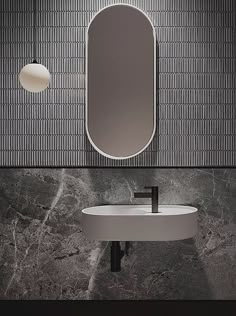 there is a sink and mirror in the bathroom with grey marble wall tiles on the walls