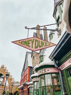 there is a sign that says honey dukes on the side of a building in an old town