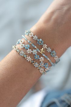 🌊💙 The Sky Blue Set 💙☁️ You can order each bracelet separately This amazing flower bracelet set includes 4 bracelets which add some spice to any fit. If you like summer vibes then this set is perfect for you! It has the colour of a clear sky on a beautiful sunny day and it reminds you of the ocean breeze. Glass beads sparkle beautifully in the light. This is an absolute eye-catcher and be ready to get a lot of compliments!  Each bracelet ends in a cute gold filled flower hanging from the exte Bead Projects, Diy Bracelet Designs, Diy Bracelets Patterns, Beading Techniques, Beads Bracelet Design, Handmade Jewelry Tutorials, Jewelry Accessories Ideas, Bracelet Ideas, Jewelry Lookbook