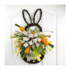 a wreath with carrots and flowers hanging on the front door to give as an easter decoration