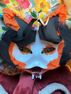 an animal mask with orange and black hair