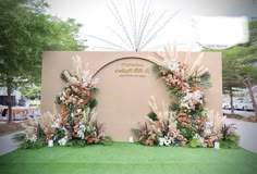 an arrangement of flowers and greenery on display in front of a sign for the wedding ceremony