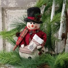 a snowman sitting on top of a potted plant