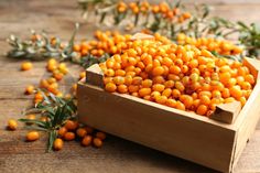 small orange berries in a wooden box on a table