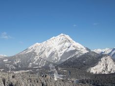 the mountains are covered in snow and trees