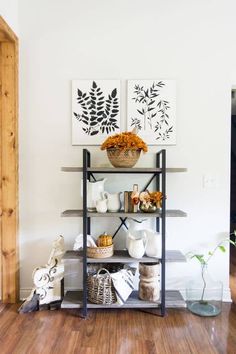 a shelf filled with vases and other items on top of a hard wood floor