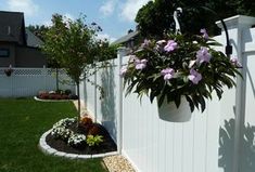 a white fence with flowers growing in it