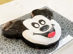 a cake shaped like a monkey on top of a white and black tableclothed surface