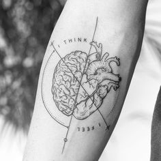 a black and white photo of a human heart tattoo on the left upper half of the arm