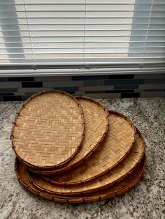 four wicker plates sitting on top of a counter