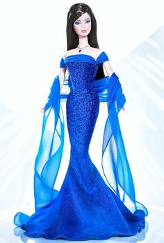 a barbie doll wearing a blue gown and holding a trophy in her hand, on a white background