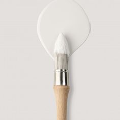 a white paint brush with a wooden handle