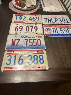 four license plates sitting on top of a wooden table