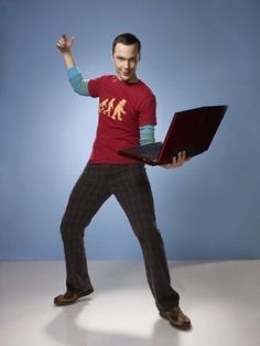 a young man holding a laptop computer in his right hand while standing on one leg