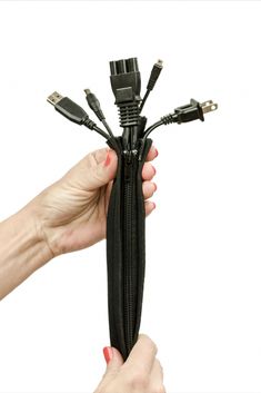 a hand holding a black zipper with multiple wires