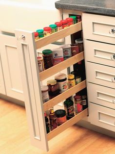 an open spice rack in the corner of a kitchen cabinet with spices and condiments