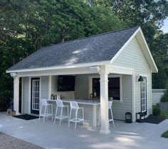 a small backyard bar with white chairs