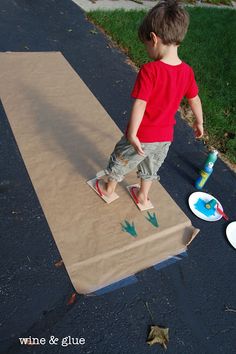 a young boy standing on top of a cardboard box