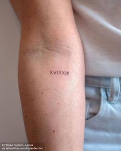 a woman's arm with the word xxvix tattooed on her left arm