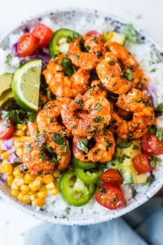 a bowl filled with shrimp and vegetables on top of rice, garnished with cilantro