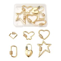 gold plated metal charms with heart, star and arrow shapes in various sizes on a white background