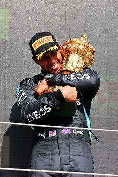 a man holding a gold glove on top of his head in front of a screen