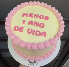 a cake with pink frosting and writing on the top that says menos i amo de uda