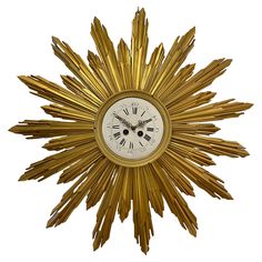 a golden clock with roman numerals on the face