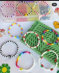 several bracelets and beads sitting on top of a green tray next to plastic containers