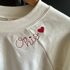 -Supersoft Pullover Sweatshirt With Ribbed Cuffs -Relaxed Fit -Falls Right At The Hip -52% Airlume Cotton, 48% Polyester Fleece -Bella Canvas Antique White Sweatshirt With Red Ohio Heart Embroidery Around Neck Embroidered Holiday Sweatshirt, Custom Embroidery Loungewear Tops, Custom Embroidered Relaxed Fit Tops For Loungewear, Long Sleeve Tops With Embroidered Logo For Loungewear, Relaxed Fit Tops With Custom Embroidery For Loungewear, Long Sleeve Top With Embroidered Text For Loungewear, Cute Embroidered Text Tops For Fall, Cotton Long Sleeve Tops With Letter Embroidery, Cute Tops With Embroidered Text For Fall