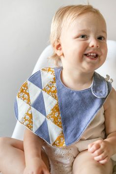 a baby sitting in a high chair wearing a bib