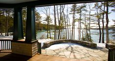 the porch is covered with snow and has a view of the lake from it's deck