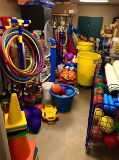 a room filled with lots of toys and plastic buckets on the floor next to each other