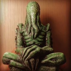 a green statue sitting on top of a wooden table