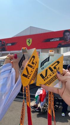 two people holding up their medals in front of a race track