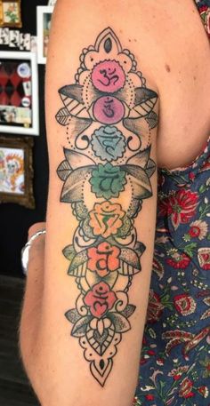 a woman's arm with tattoos on it and an image of flowers in the middle