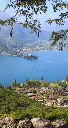 a scenic view of the lake and mountains from above, looking down on some houses