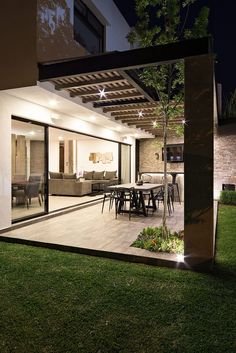 an outdoor living room and dining area are lit up at night