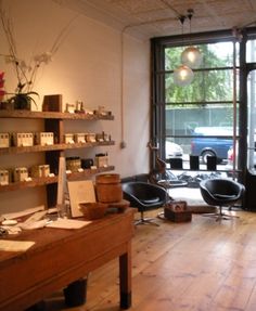 an empty room with chairs, desks and shelves full of items in front of large windows