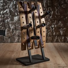 a wine rack made out of wood and metal stands on top of a wooden floor