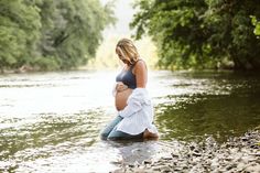 a pregnant woman sitting in the water with her belly wrapped around her waist and looking down