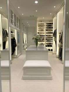 a walk in closet filled with lots of white furniture and shoes on the shelves next to each other