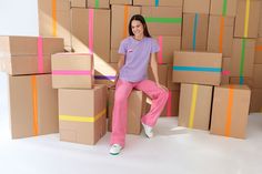 a woman sitting on top of cardboard boxes