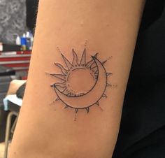 a small sun and moon tattoo on the arm