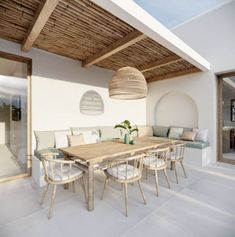 an outdoor dining area with wooden table and chairs, white tile flooring and wood ceiling