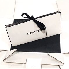 a black and white box with a bow on it that says chanel in the center